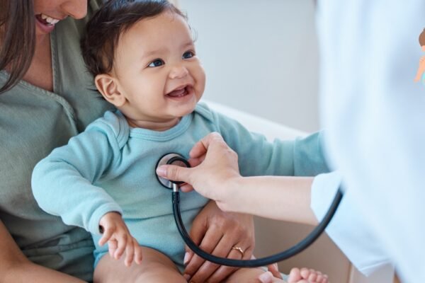 Top 7 Benefits of Regular Pediatric Visits Every Parent Should Know Pediatrician examining a smiling child during a regular health checkup in a bright clinic.